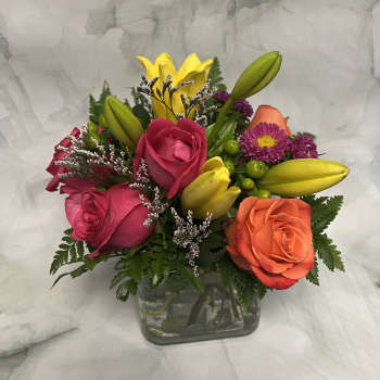 Mixed bouquet of roses and lilies in a glass vase