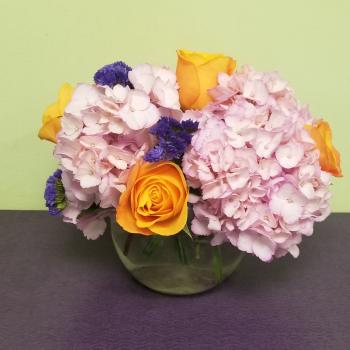 Pink hydrangeas with yellow roses in a glass vase