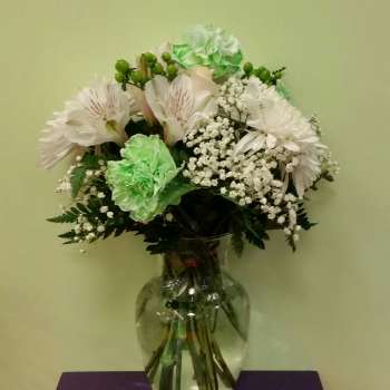 White and green bouquet in a clear glass vase