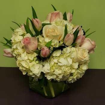 Pink and white roses with hydrangeas in a glass vase