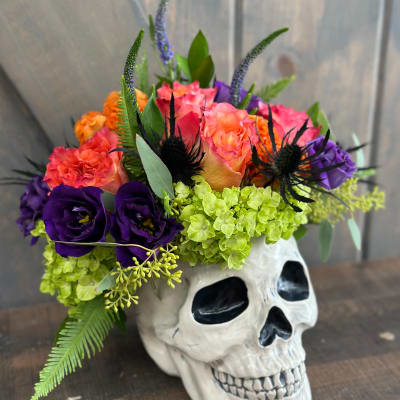 Colorful flowers arranged in a white skull vase