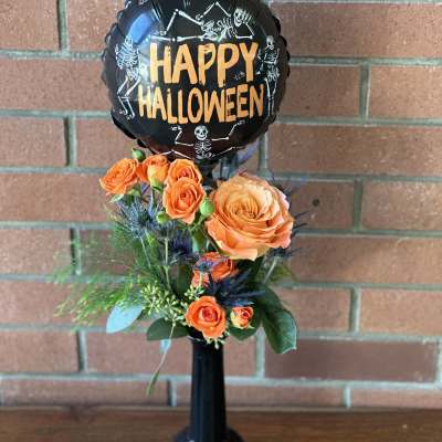 Orange roses with a Halloween balloon in a black vase