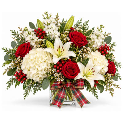 Red roses and white lilies in a glass vase with a plaid bow