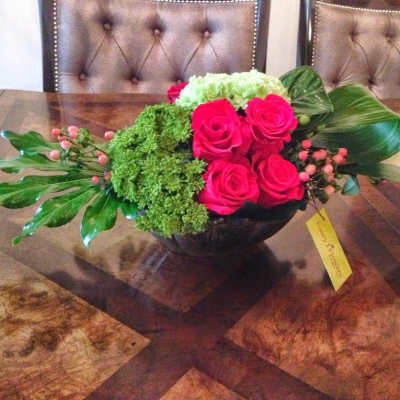 Pink roses and green hydrangea in a low black bowl centerpiece