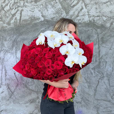 Large bouquet of red roses with white orchids wrapped in red paper