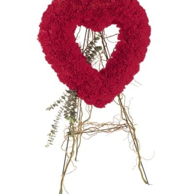 Red heart-shaped floral wreath on a stand