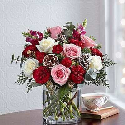 Bouquet of pink and white roses with red carnations in a glass vase