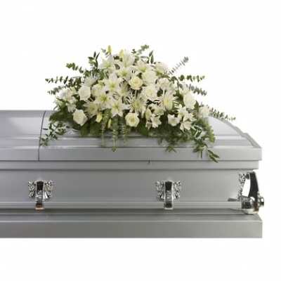 White floral casket spray on a silver casket