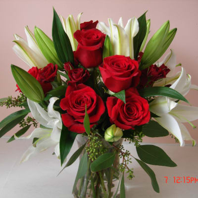 Bouquet of red roses and white lilies in a clear glass vase