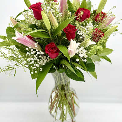 Red roses and pink lilies in a clear glass vase