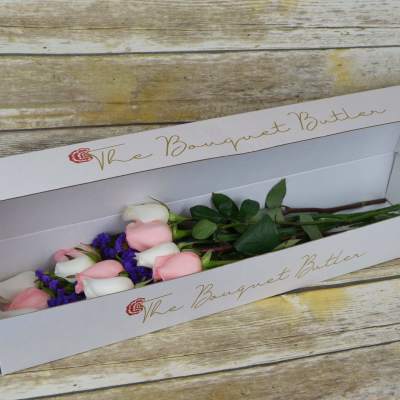 Pink and white roses in a long white gift box