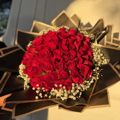 Bouquet of red roses with baby's breath in black wrapping