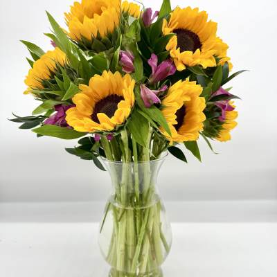 Sunflowers and purple alstroemeria in a clear glass vase