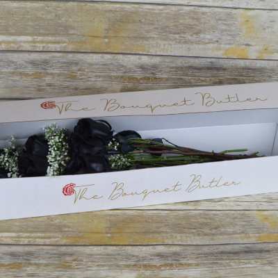 Black roses in a white bouquet box with baby's breath