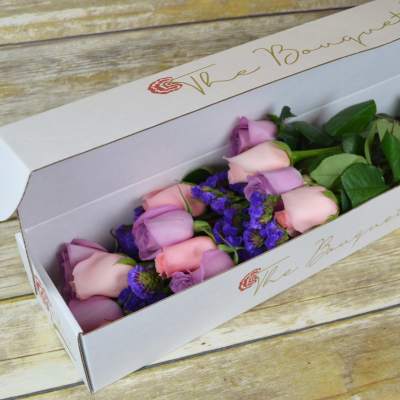 Pink and lavender roses in a white gift box