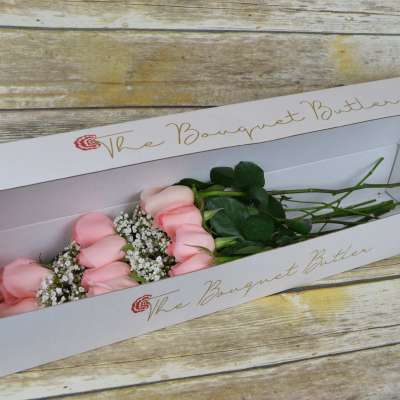 Pink roses in a white bouquet box