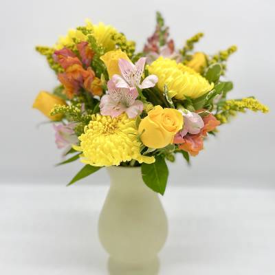 Yellow and pink mixed bouquet in a pale vase
