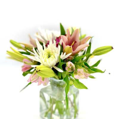 Bouquet of lilies, white chrysanthemum, and pink alstroemeria in a glass vase