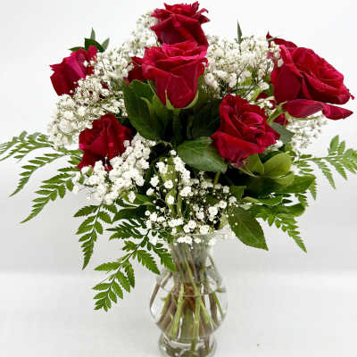Red roses and white baby's breath in a clear glass vase