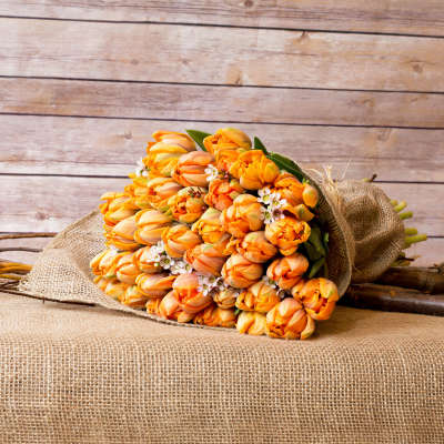 Bouquet of orange tulips wrapped in burlap