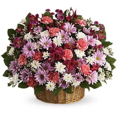 Mixed pink, purple, and white flowers in a wicker basket