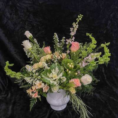 Mixed pastel floral arrangement in a white vase