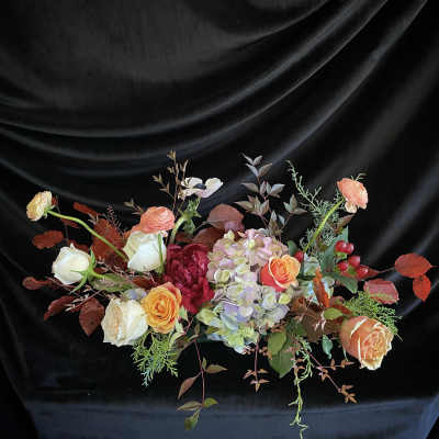 Mixed bouquet of roses and hydrangeas on a black draped background