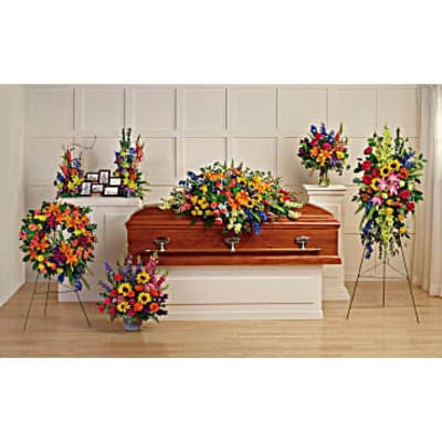 Colorful funeral casket spray with standing floral tributes