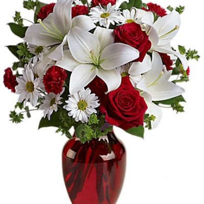 Red roses and white lilies in a red glass vase