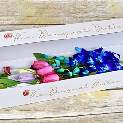 Box of colorful flower stems with blue orchids and pink blooms