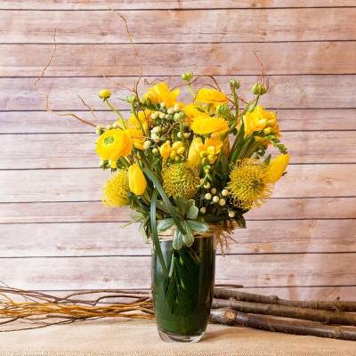 Yellow floral arrangement in a clear glass vase