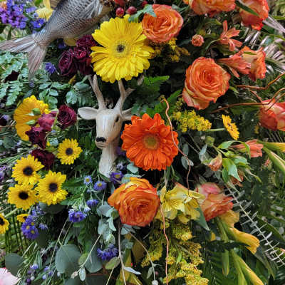 Large mixed flower arrangement with a fish and deer decoration