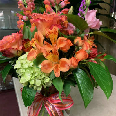 Colorful mixed bouquet in a glass vase with a ribbon bow