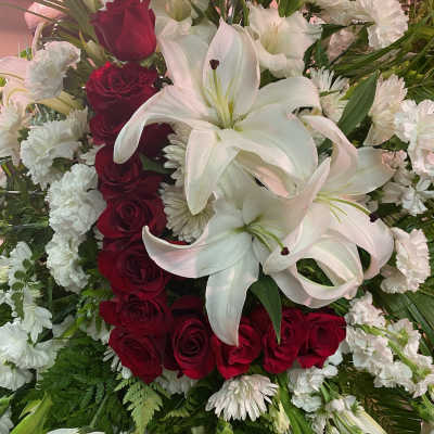 Red roses and white lilies arranged with white carnations