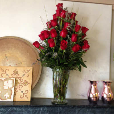 Tall bouquet of red roses in a clear glass vase