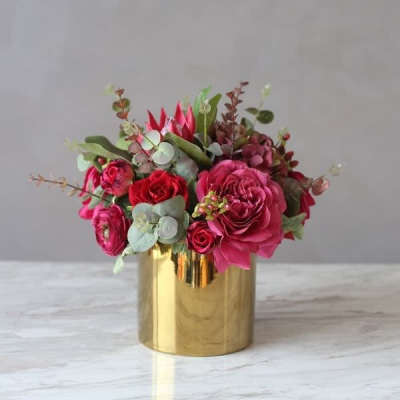 Pink and red roses arranged in a gold vase