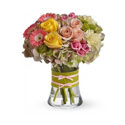 Mixed bouquet of roses, gerbera daisies, and hydrangeas in a glass vase