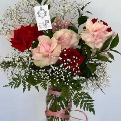 Pink and red roses in a glass vase with baby's breath