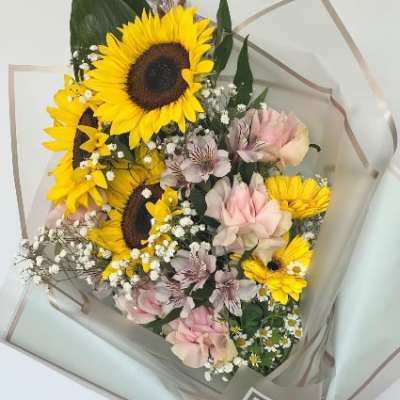 Bouquet of sunflowers and pink roses with small white filler flowers