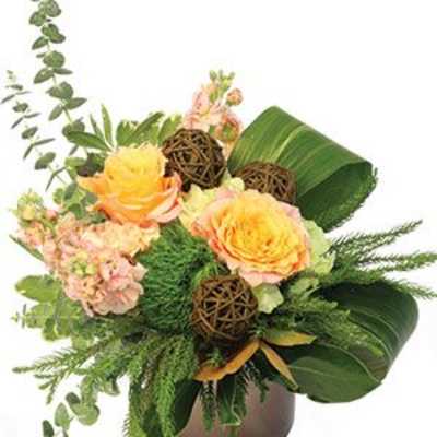Bouquet of peach roses and pink flowers in a brown vase