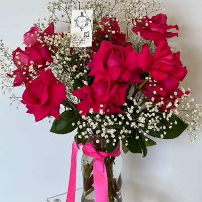 Bouquet of hot pink roses with baby's breath in a glass vase