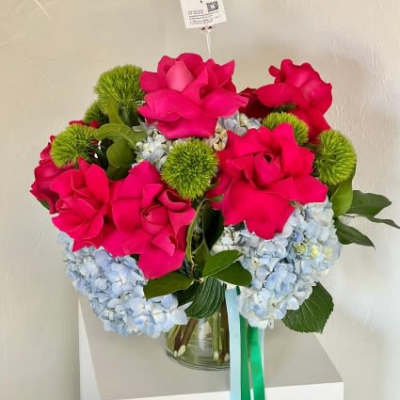 Bouquet of hot pink roses and blue hydrangeas in a glass vase