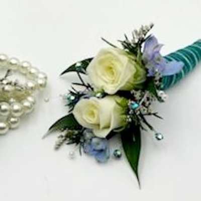 White rose corsage with blue ribbon and pearl accents