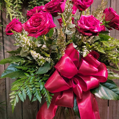 Pink roses in a glass vase with a large satin bow