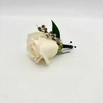 White rose boutonniere with tiny white filler blooms and black-wrapped stem on a white background