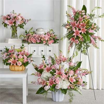 Pink and white sympathy floral set with lilies and roses around a cremation urn and standing spray.