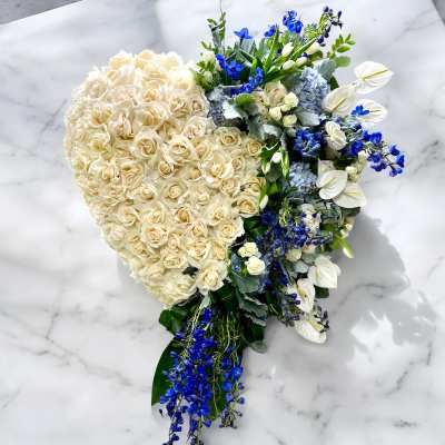 Heart-shaped bouquet of cream roses with blue and white flowers