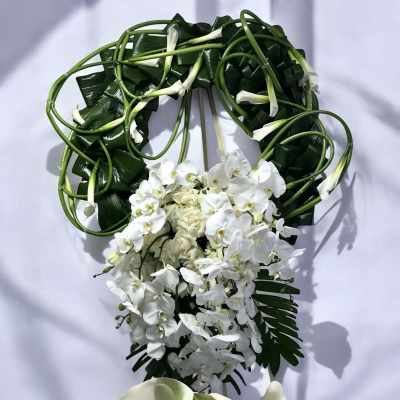 White orchid and calla lily floral arrangement with dark green foliage