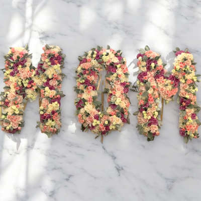 Floral letters spelling "MOM" made of pastel roses