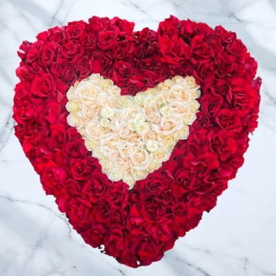 Heart-shaped arrangement of red and cream roses